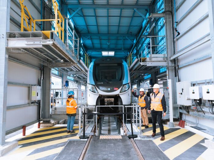 Train Ile-de-France Mobilités vue de face dans le technicentre Trappes-Montrouge avec trois personnes devant